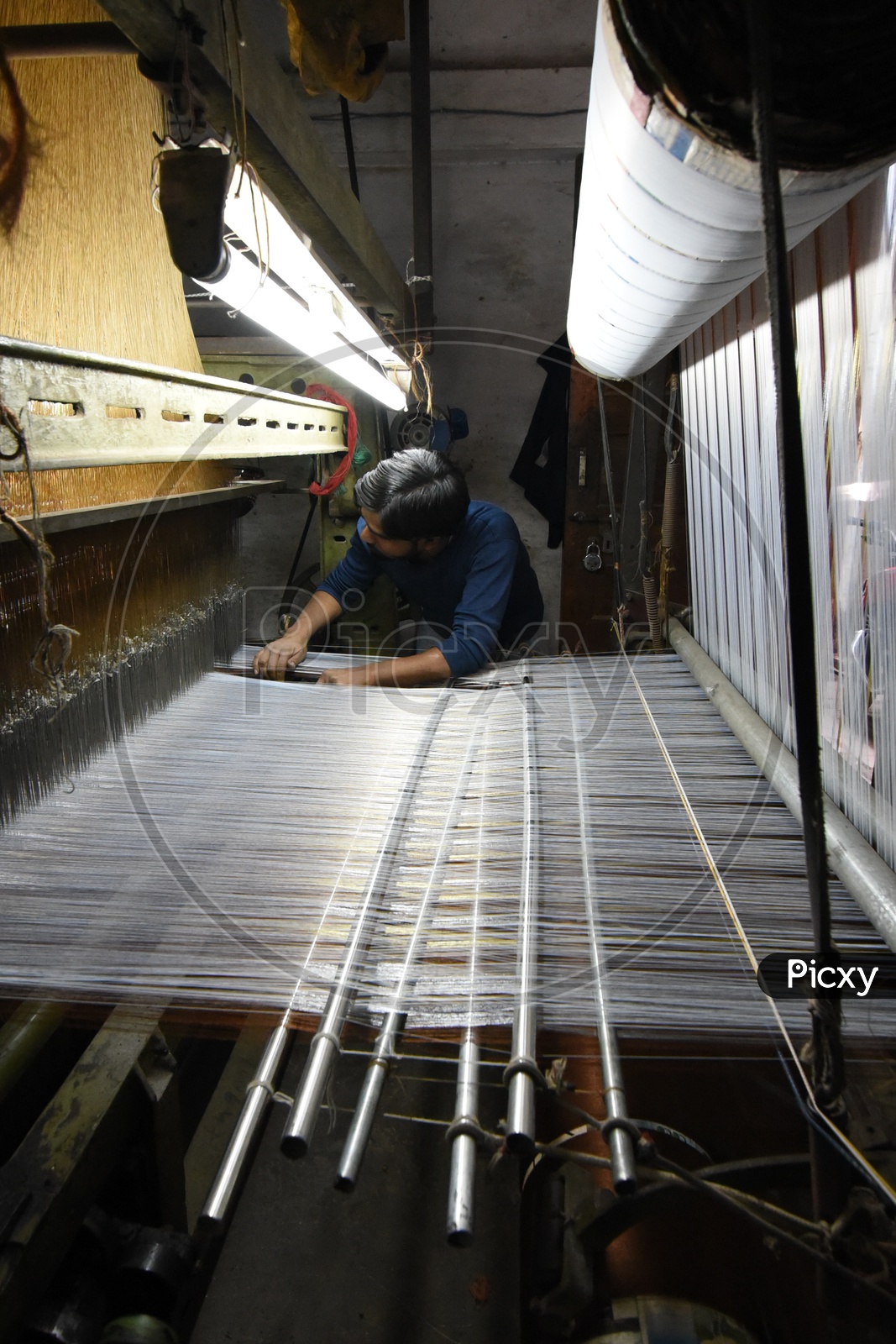 A Weaver Weaving Handloom Clothes in Machine
