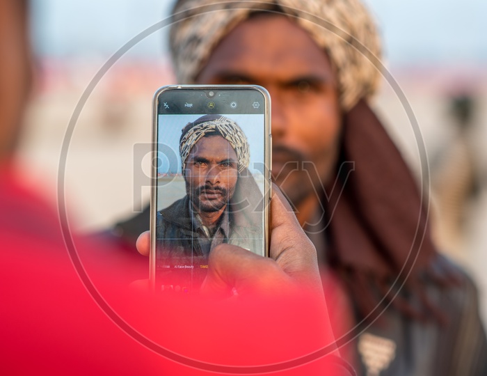 A Man Taking a Picture Of a Local Man In Kumbh Mela