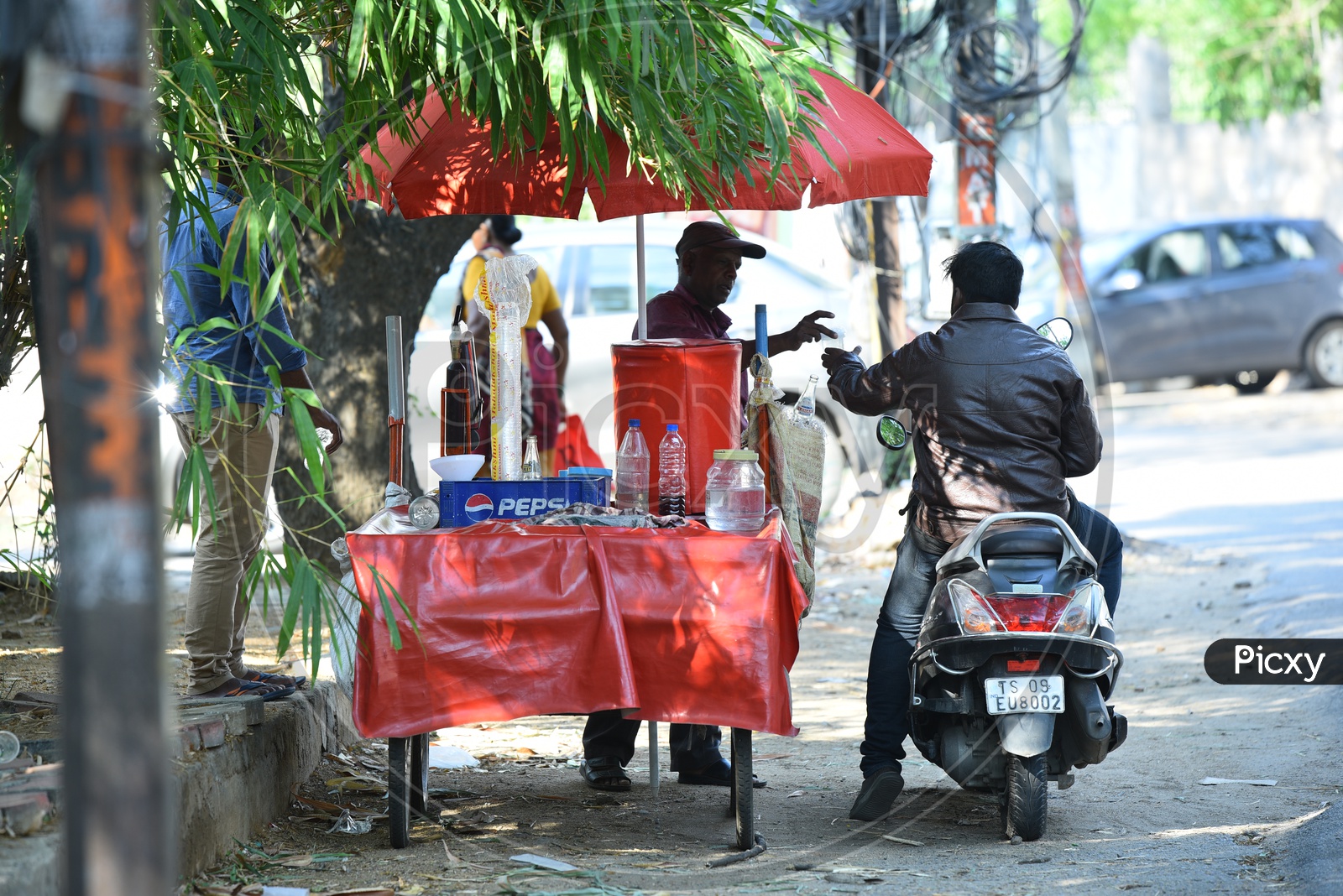 A Biker drinking Lemon Soda At a Road Side Street Vendor Stall