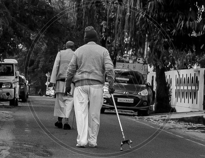 Old Aged Man Walking With The Help Of  a Walker Stick