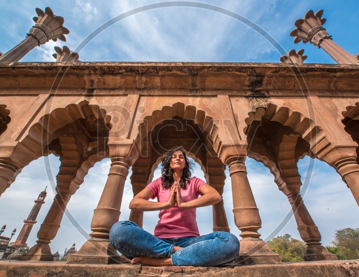 A Young Woman Practising Meditation On a Heritage Site
