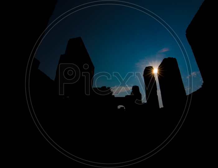 Silhouette of  Chota Imambara  With a Blue hour Sky And Sun Burst  In The Background