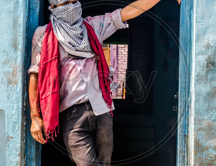 A Young Indian Man Cover His Face With a Veil and  Standing at a House Door Step