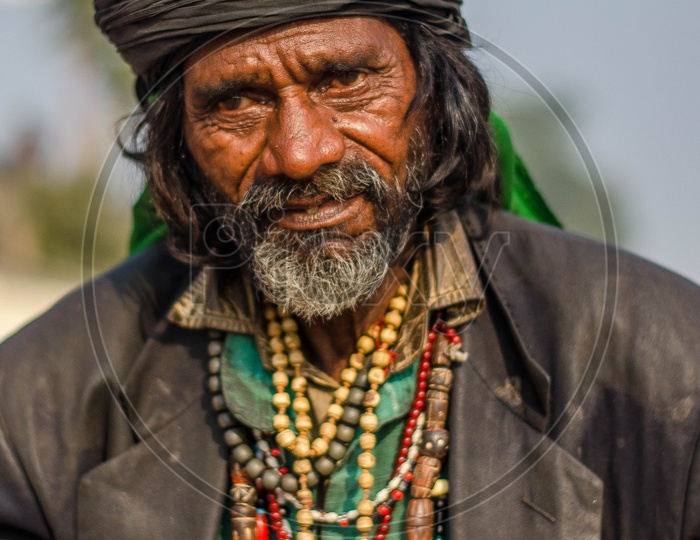 Portrait of an Indian man with black turban and wearing beaded chains