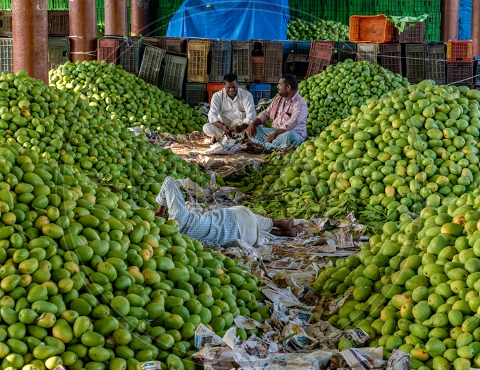 Farmers sitting in the midst of mangoes at Kothapet fruit market, Hyderabad.