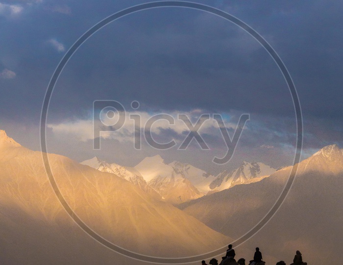 Silhouette Of Camel Rides On the River Valleys In Nubra  With Beautiful Mountain Ranges In Background