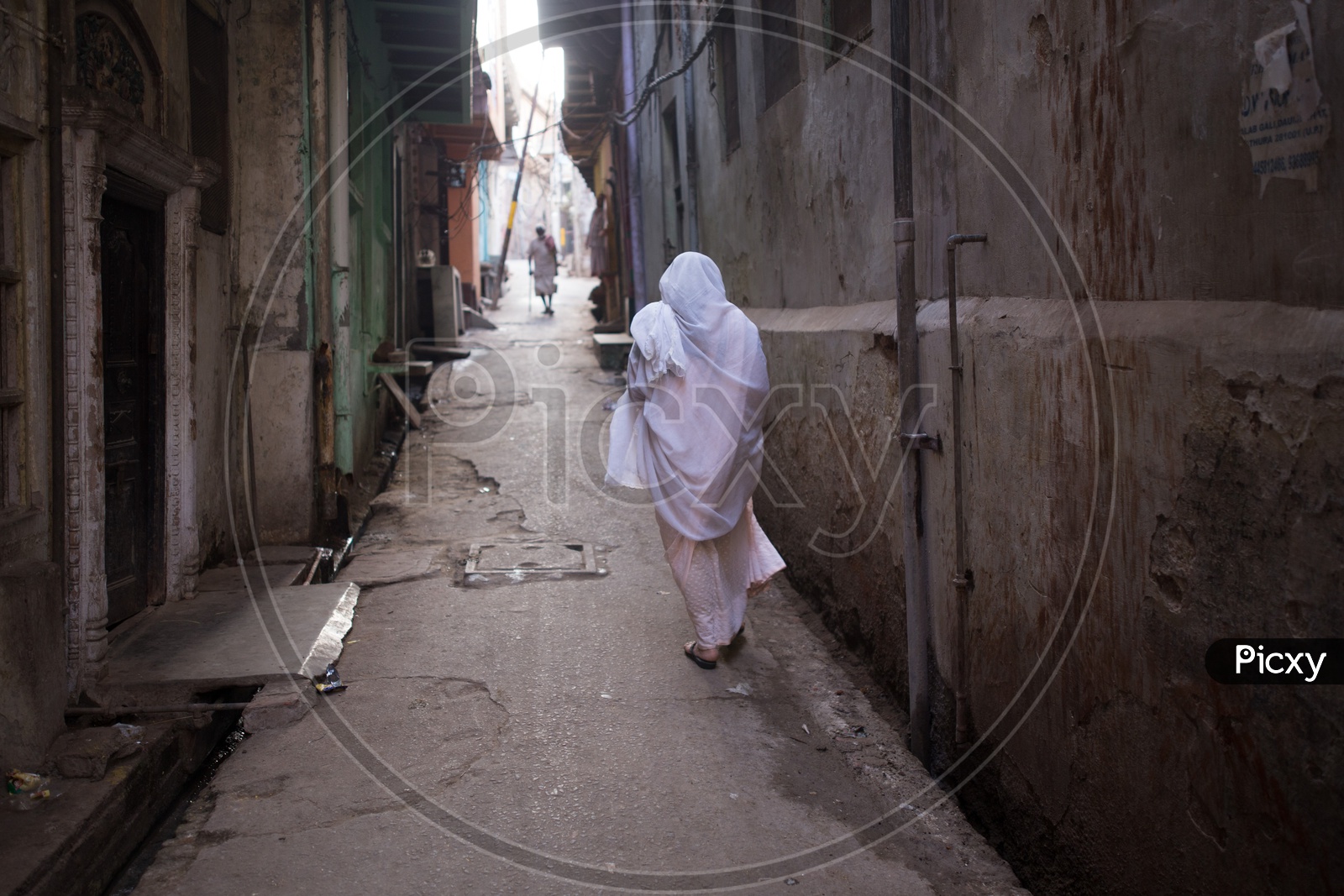 An Old Widow Woman in White clothes Walking on The Streets Of Barsana