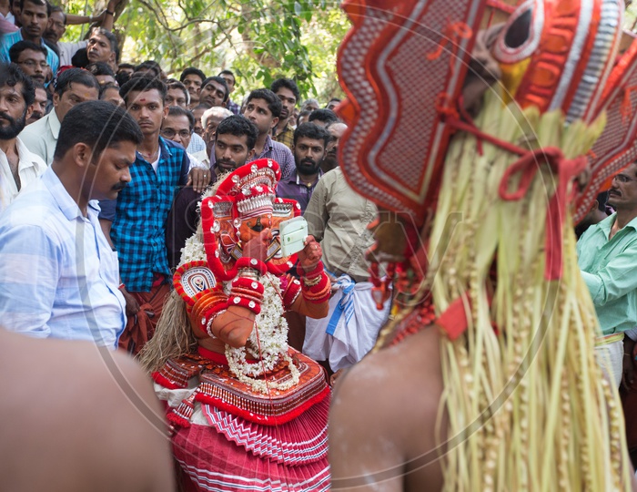 A Theyyam performer in colourful costume getting ready