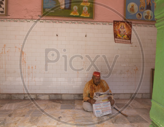 An Indian man reading newspaper