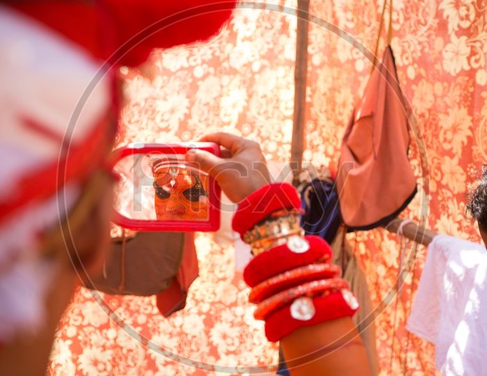 A Performer during Muchilottu Bhagavathi Theyyam looking in the mirror
