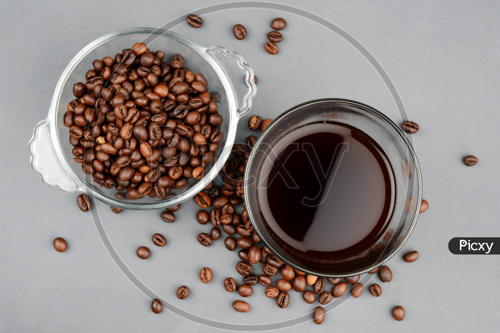 Roasted Coffee beans in a bowl with a glass of black coffee