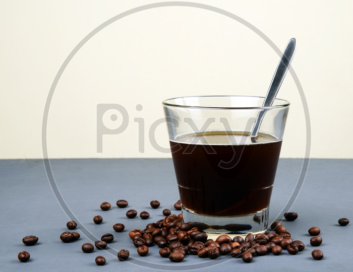 Roasted Coffee beans  with a glass of black coffee