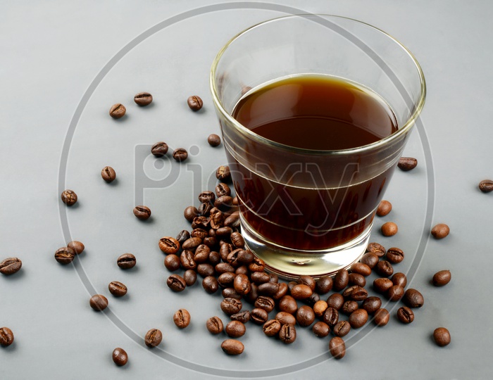 Roasted Coffee beans with a glass of black coffee