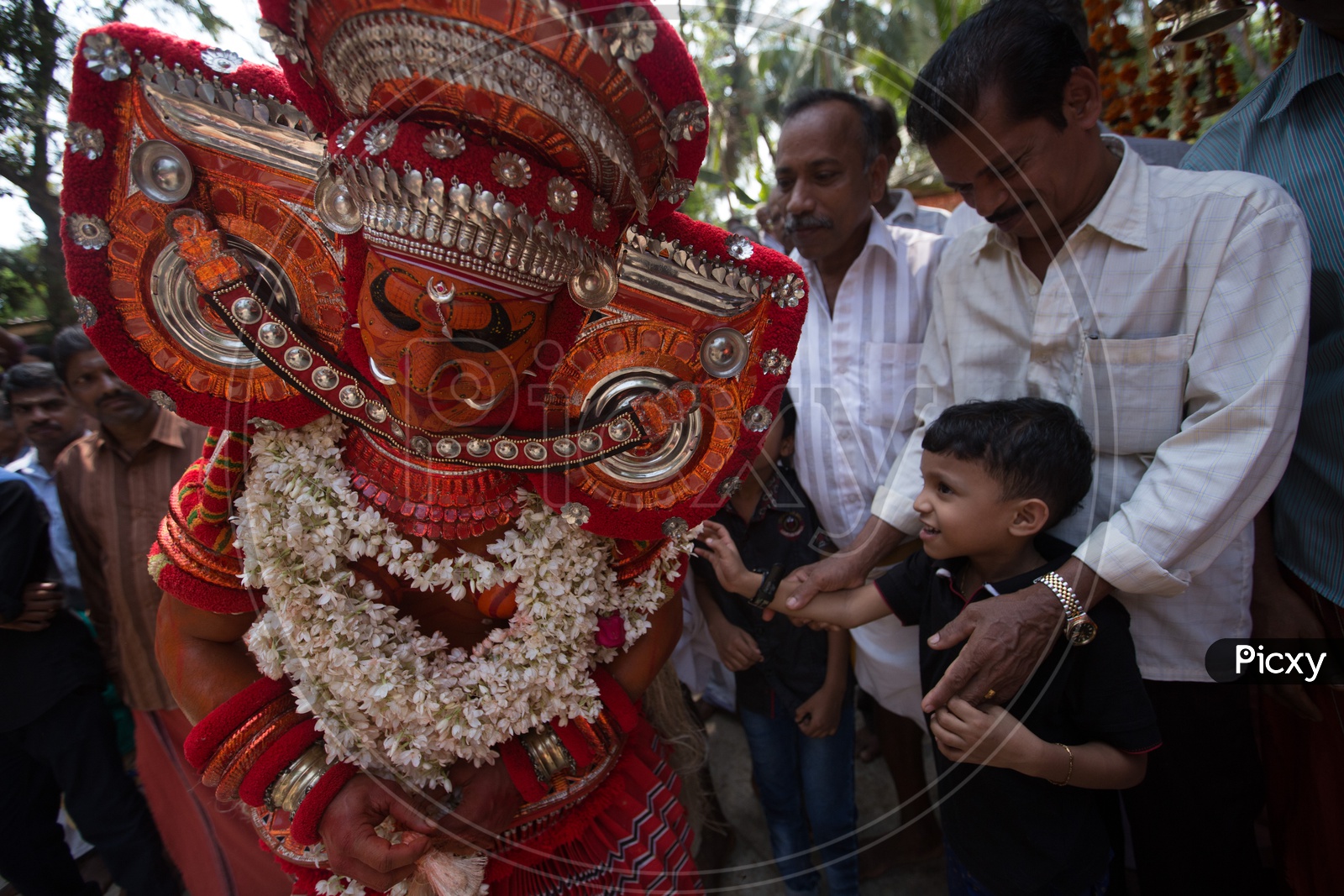 A kid touching the Theyyam Performer