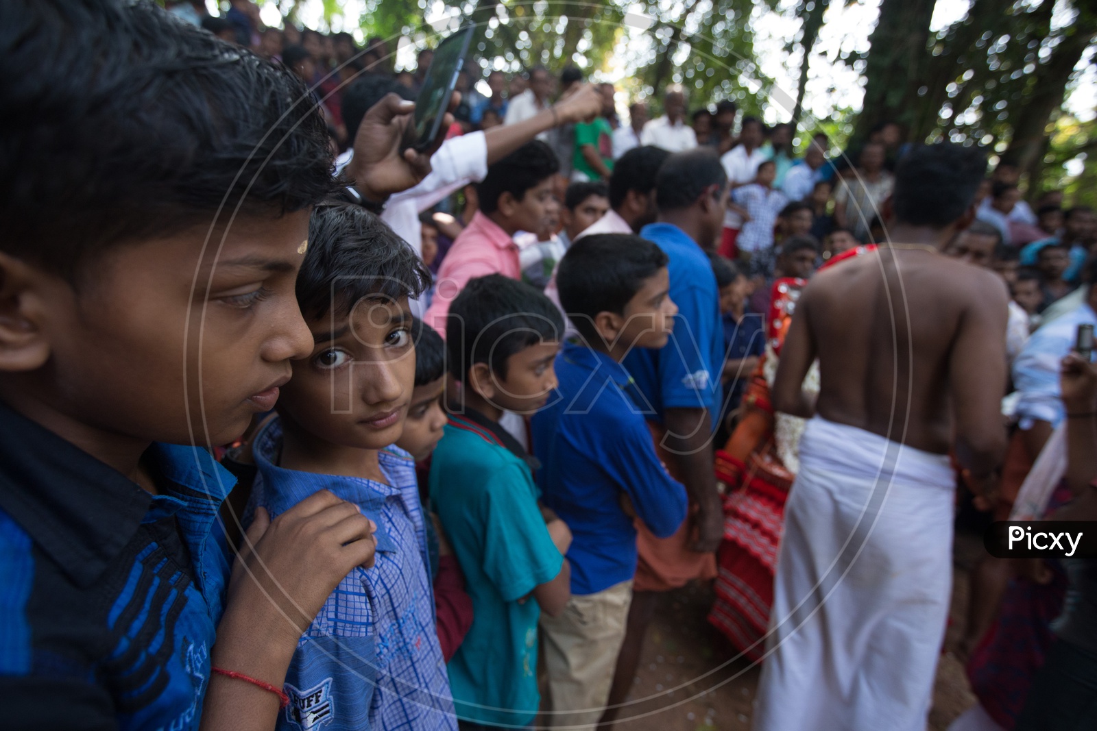 Children Watching The Theyyam  As a Crowd