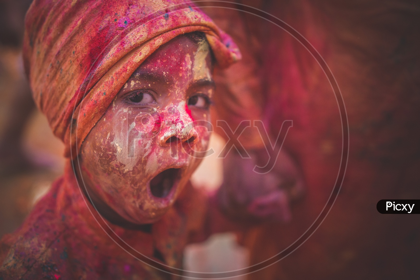 A child covered with festive Holi colors