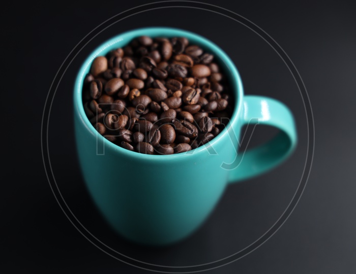 Coffee Beans In a Coffee Mug  Composition Shot On An Isolated Black Background