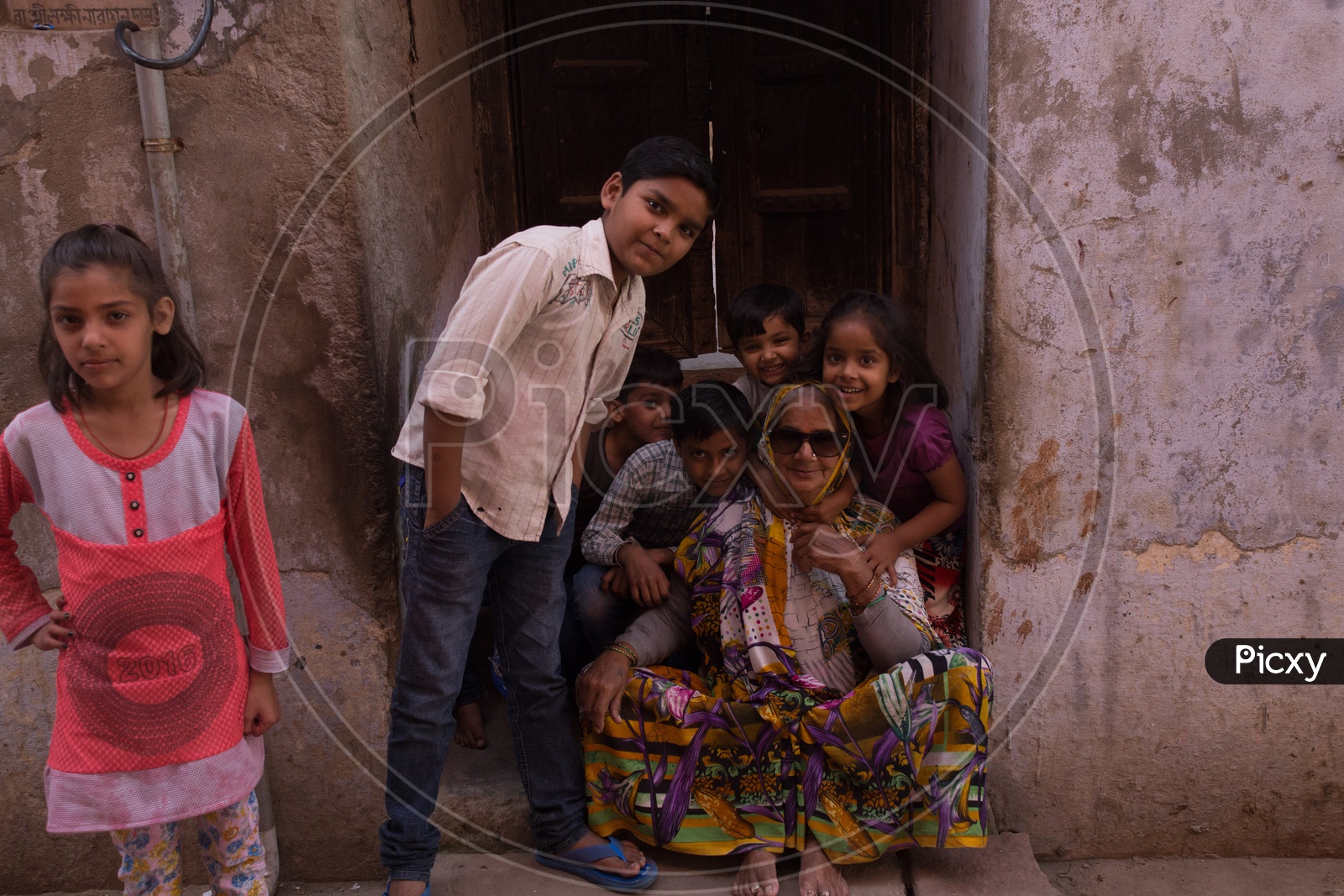 An old woman along with the children posing for a photograph