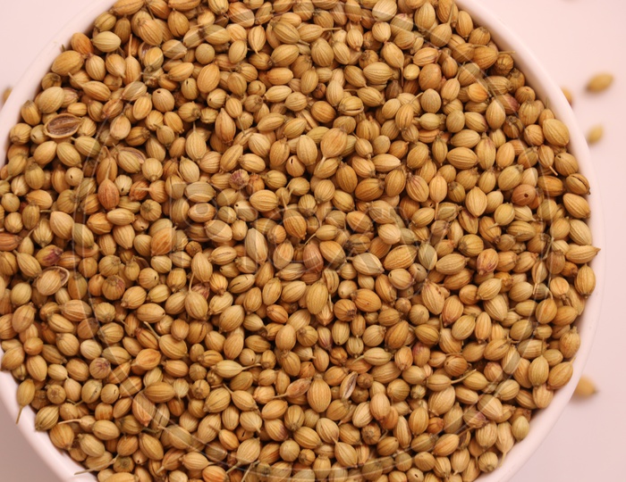 Whole and dried coriander seeds in a bowl