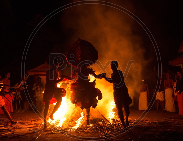 Theyyam Artists Performing around The Fire