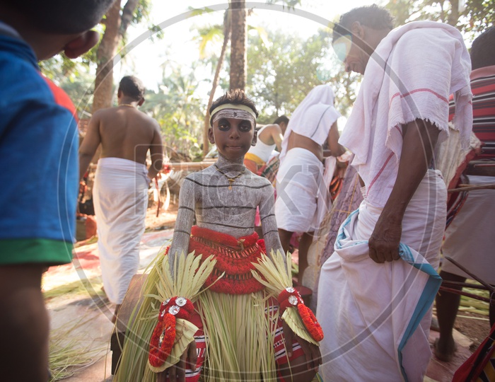 A Small Boy Theyyam Artists In Makeup For Performance , A  Ritualistic Dance Art Form  in Kerala