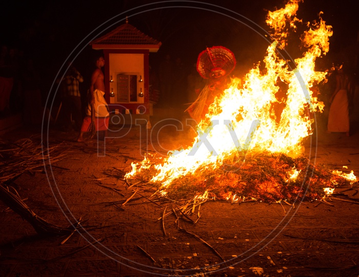 Theyyam Artists Performing around The Fire
