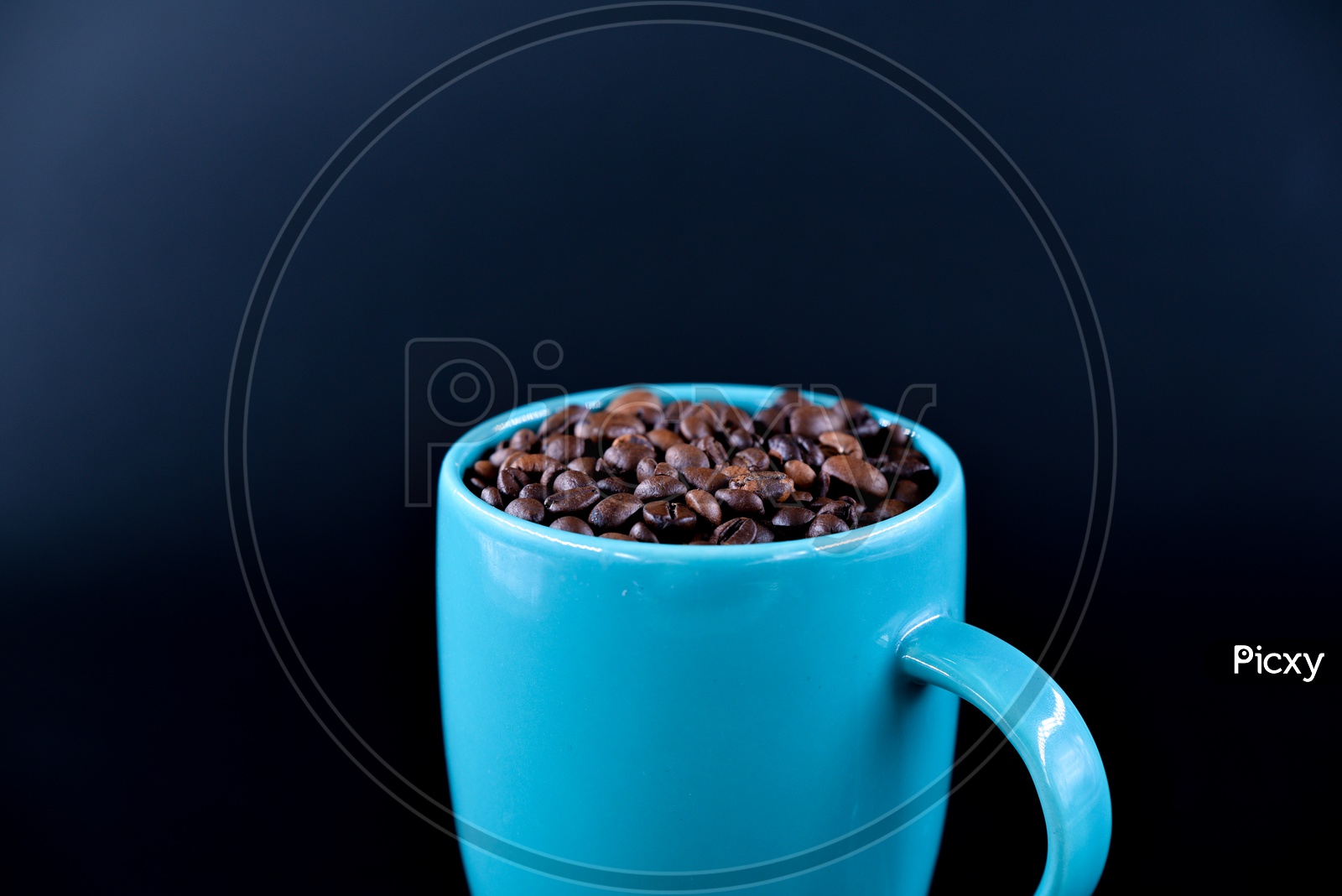 Coffee beans in a blue coffee mug on a dark background