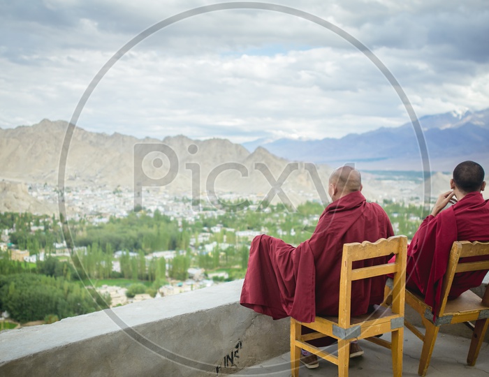 Two Buddhist Monks sitting in chairs