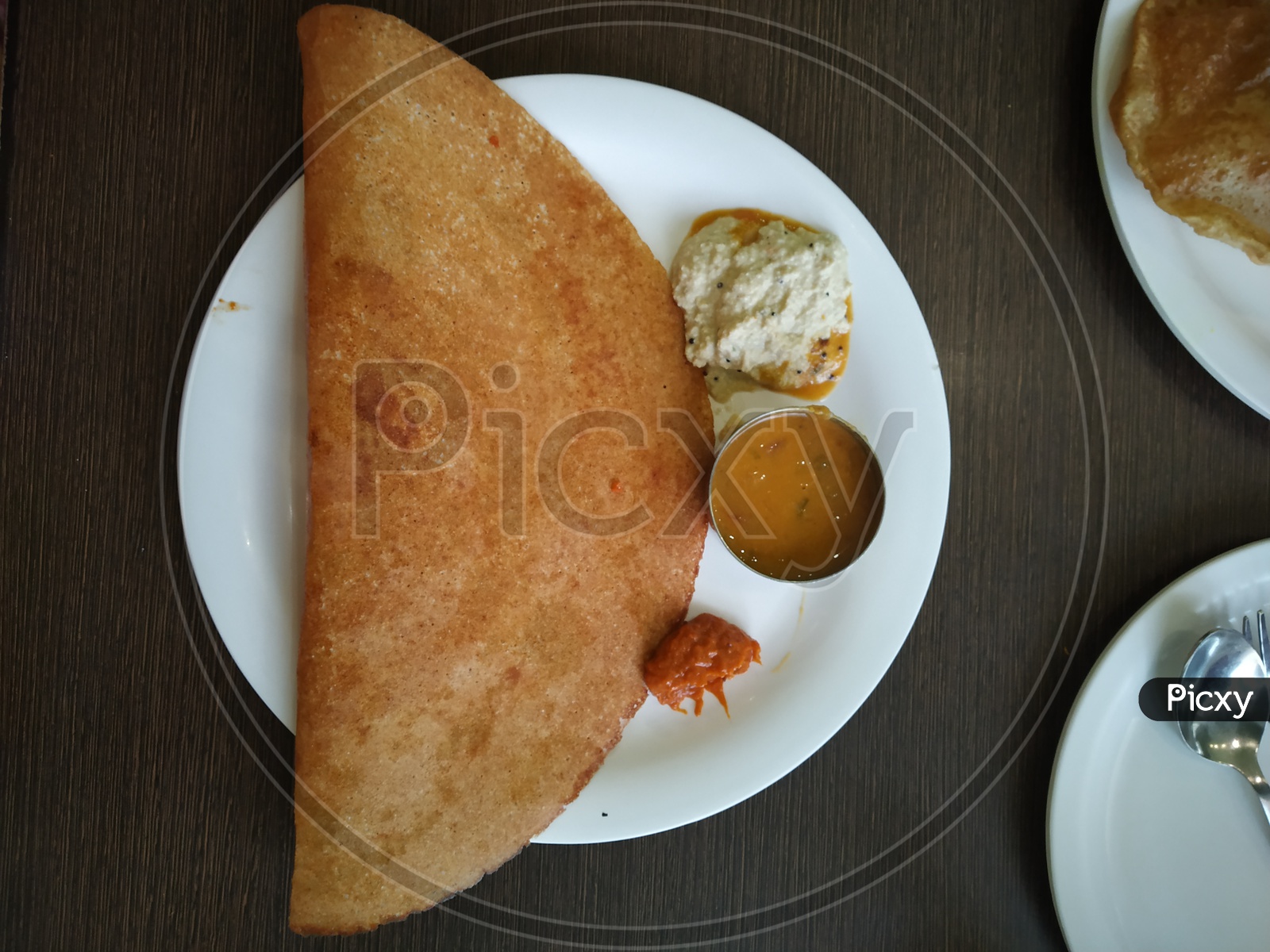 Dosa with a pickle served in a plate