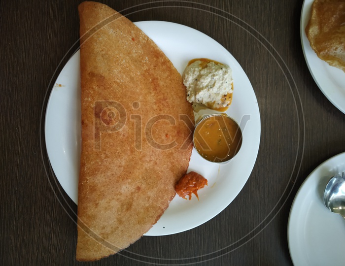 Dosa with a pickle served in a plate