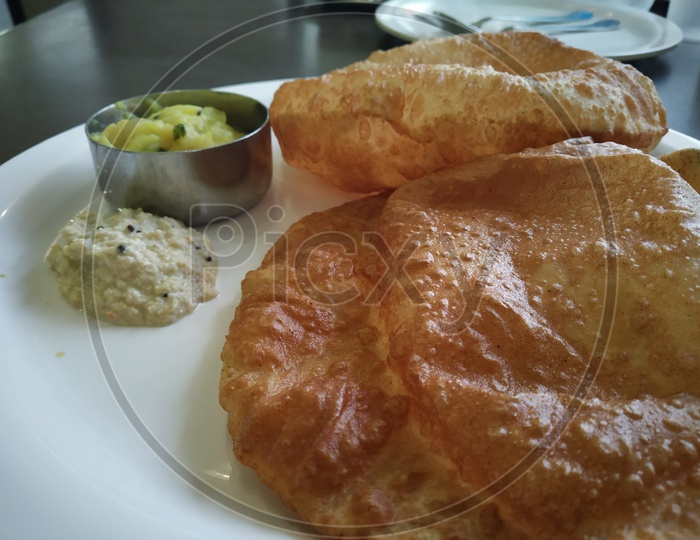 Puri with a peanut chutney and aloo curry served in a plate