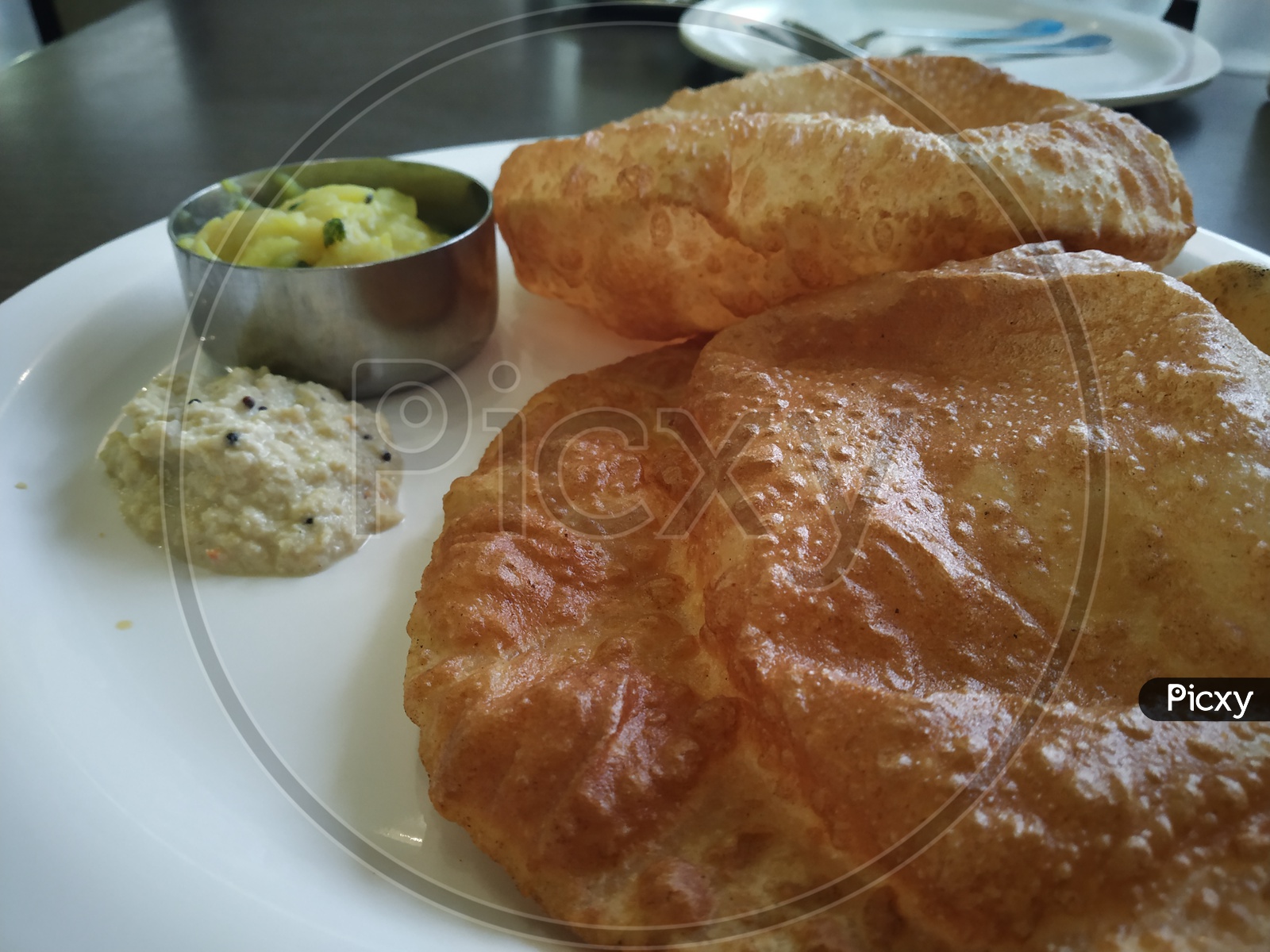 Puri with a peanut chutney and aloo curry served in a plate