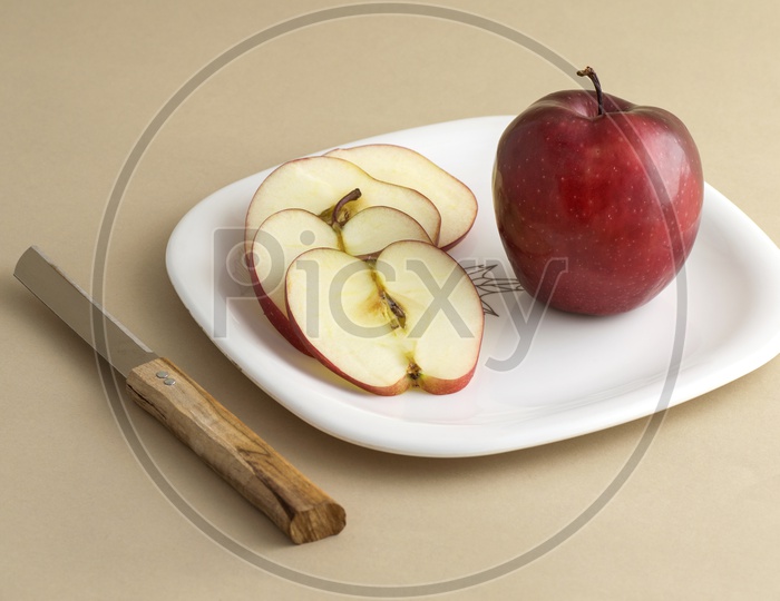 Fresh Apple Slices On White Plate With Knife And Fork On an Isolated Background