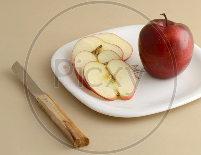 Fresh Apple Slices On White Plate With Knife And Fork On an Isolated Background