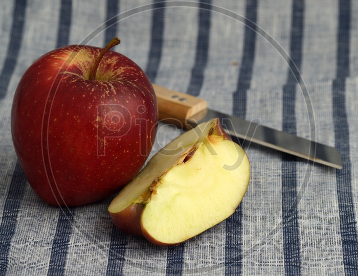 Fresh Red Apples And Slices   With Knife  on an Table Cloth Background