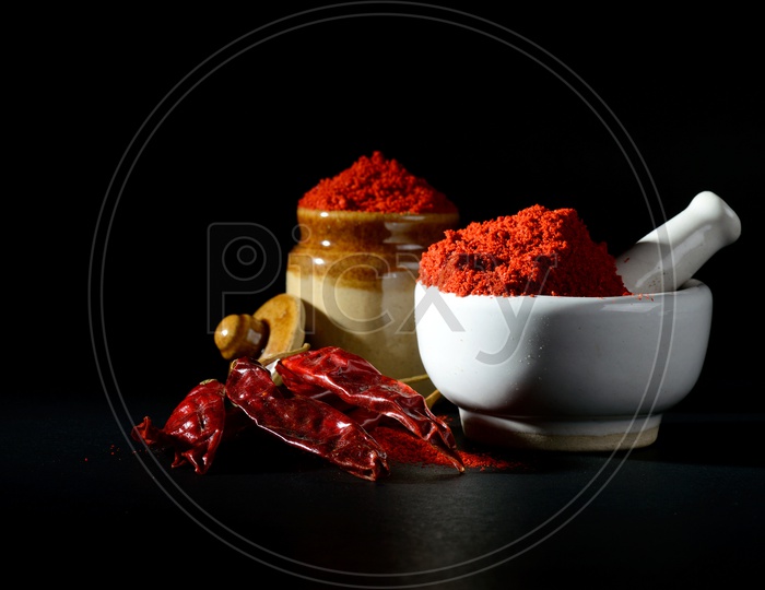chilly powder in yellow bowl on black  background. Red chilly pepper