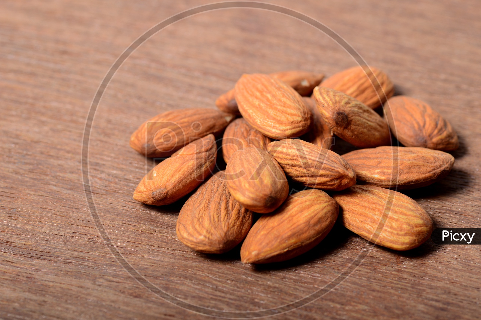 Almonds Or Badam  Nuts On An Isolated Wooden Background