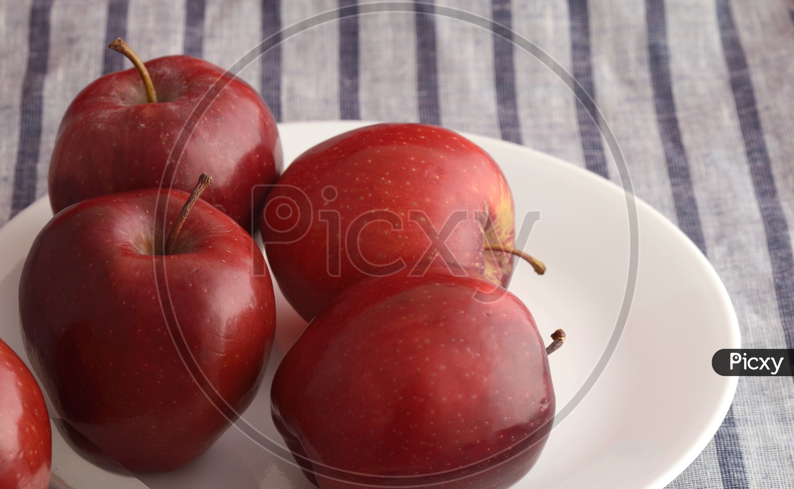 Fresh Red Apples On a White Plate  On an Table Cloth Background