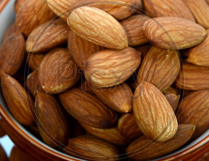Almonds Or Badam Nuts Heap  In a  Bowl On an Isolated White Background