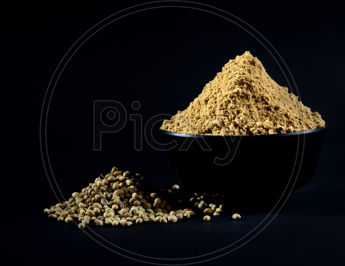 Coriander Powder and Coriander seeds on black background