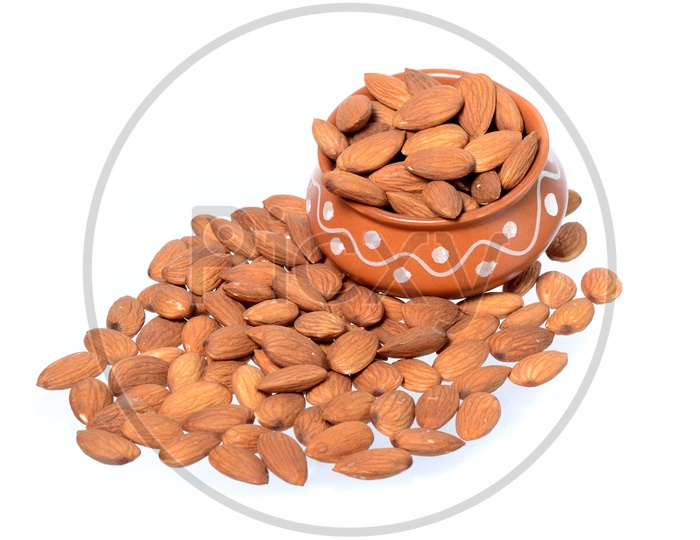 Almonds Or Badam Nuts In a Clay Bowl With a Heap On an Isolated White background