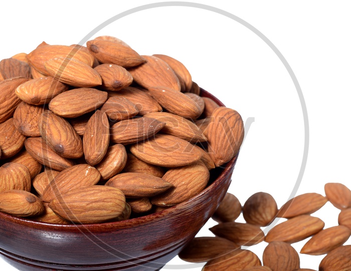 Almonds Or Badam Nuts In a Wooden  Bowl With a Heap On an Isolated White background
