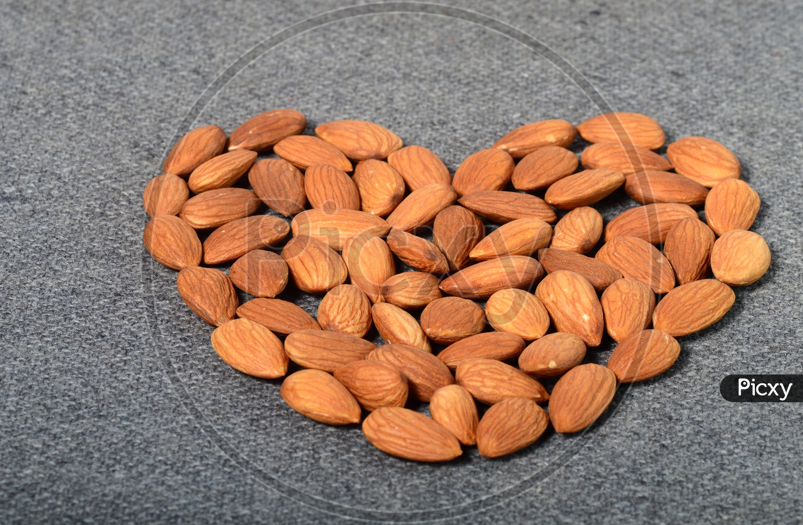 Almonds Or Badam Nuts Arranged in Heart Shape On an Isolated Background