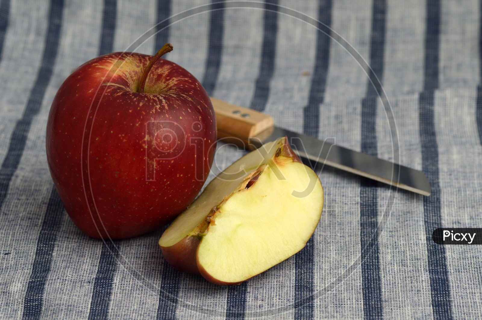 Fresh Red Apples And Slices   With Knife  on an Table Cloth Background