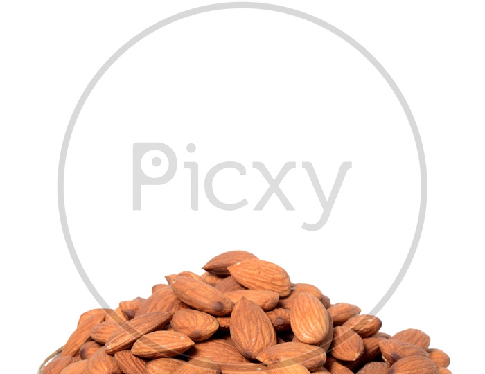 Almonds Or Badam Nuts Heap  On a Wooden Weaved Bowl On An Isolated White Background
