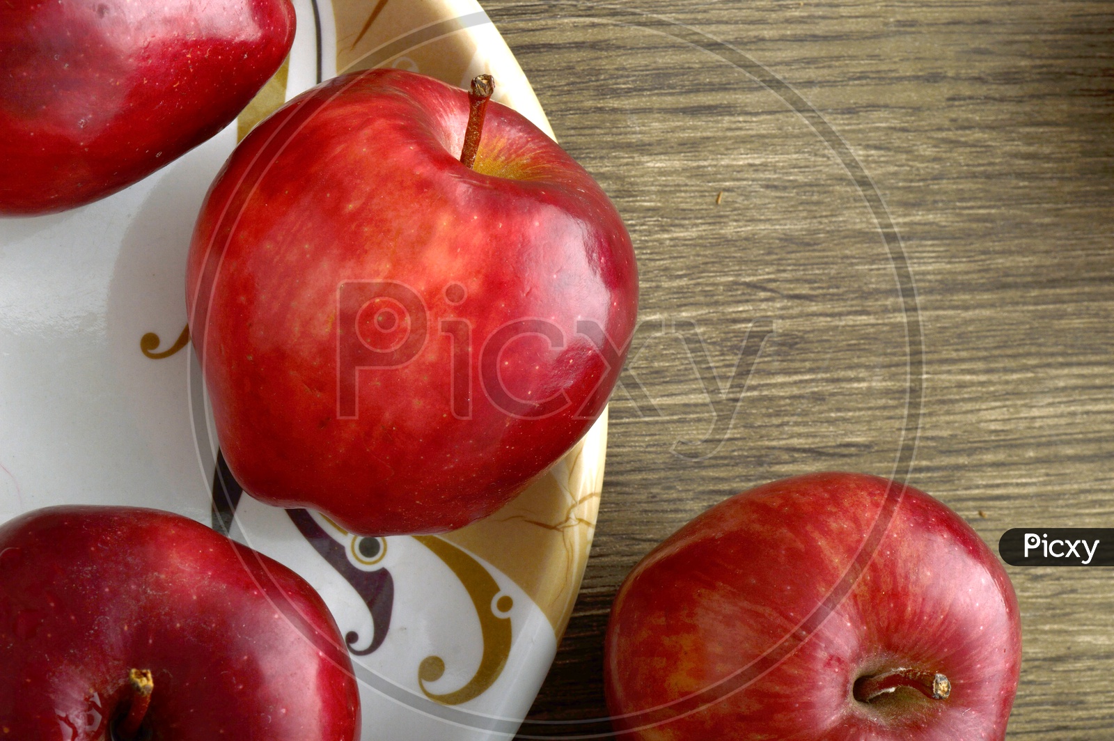 Ripen Red Apples  On a  Plate Over an Isolated Wooden Background