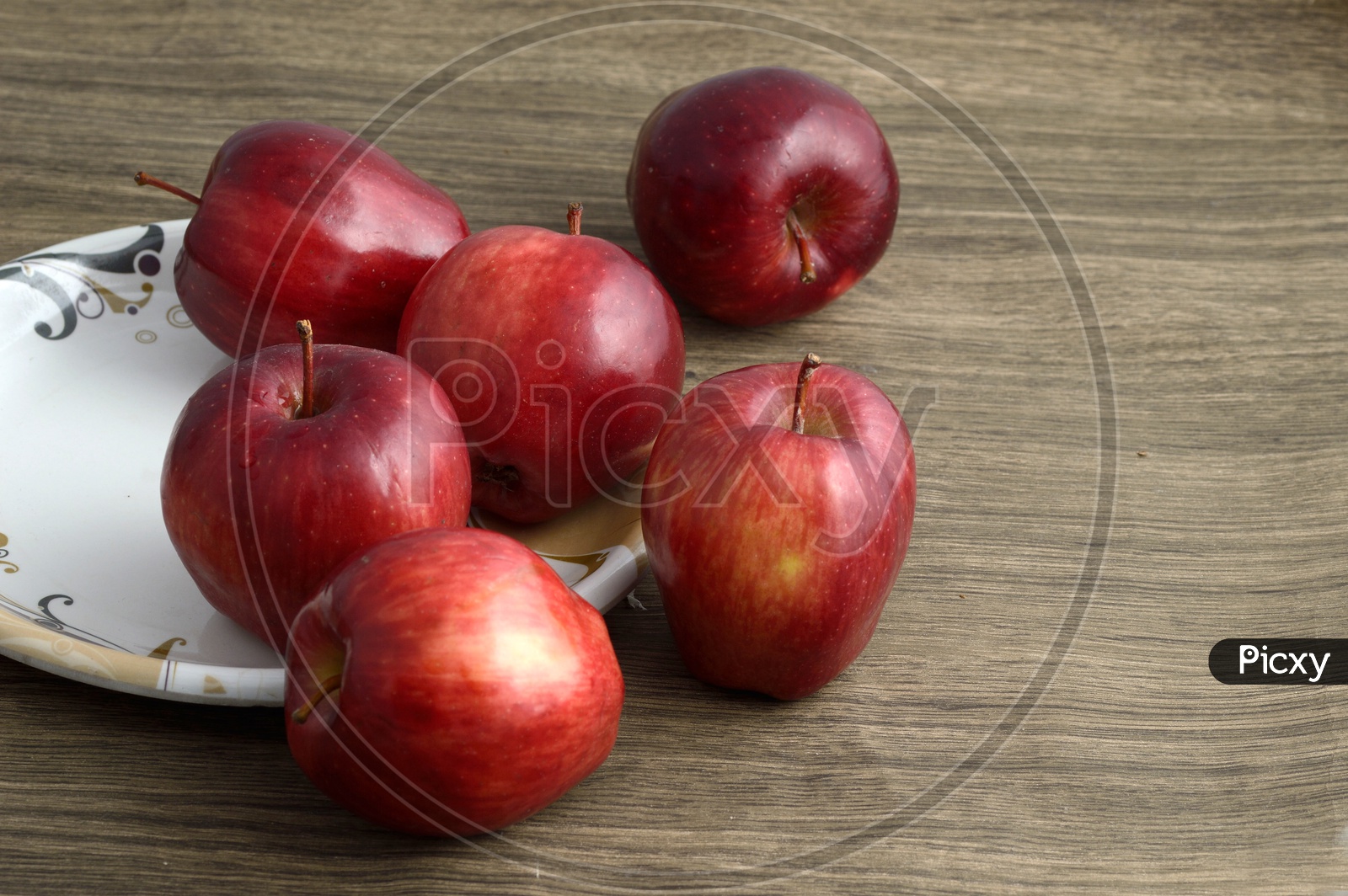 Ripen Red Apples  On a  Plate Over an Isolated Wooden Background