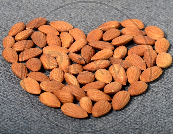 Almonds Or Badam Nuts Arranged As a Heart Shape  On an Isolated  Background