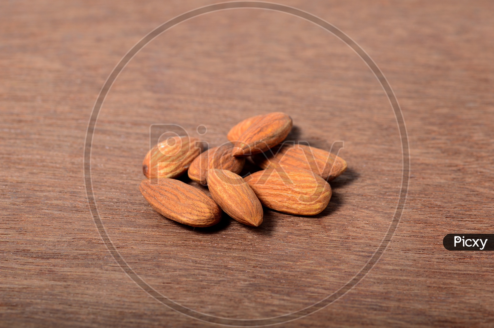 Almonds Or Badam  Nuts On An Isolated Wooden Background
