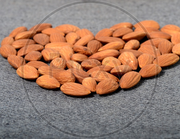 Almonds Or Badam Nuts Arranged in Heart Shape On an Isolated Background